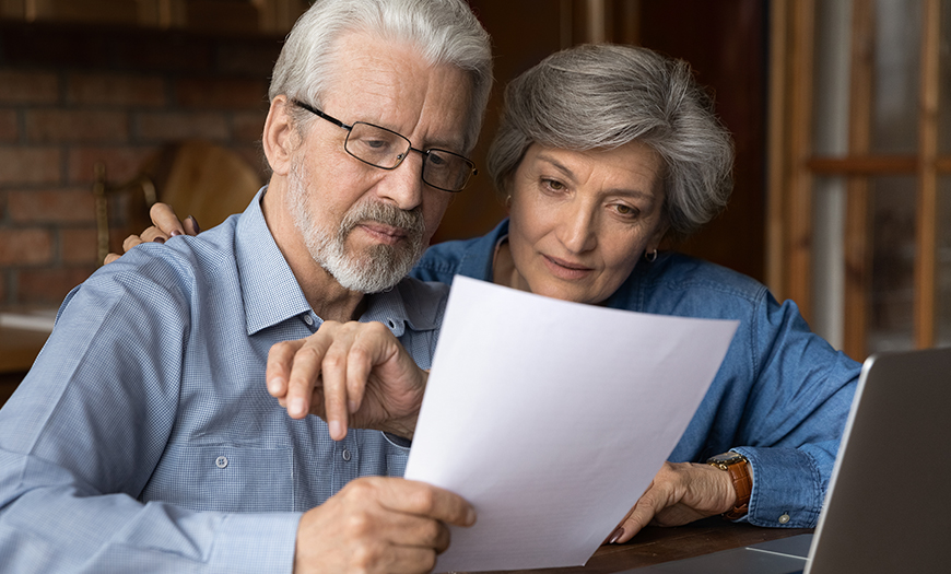middle aged couple looks at paperwork