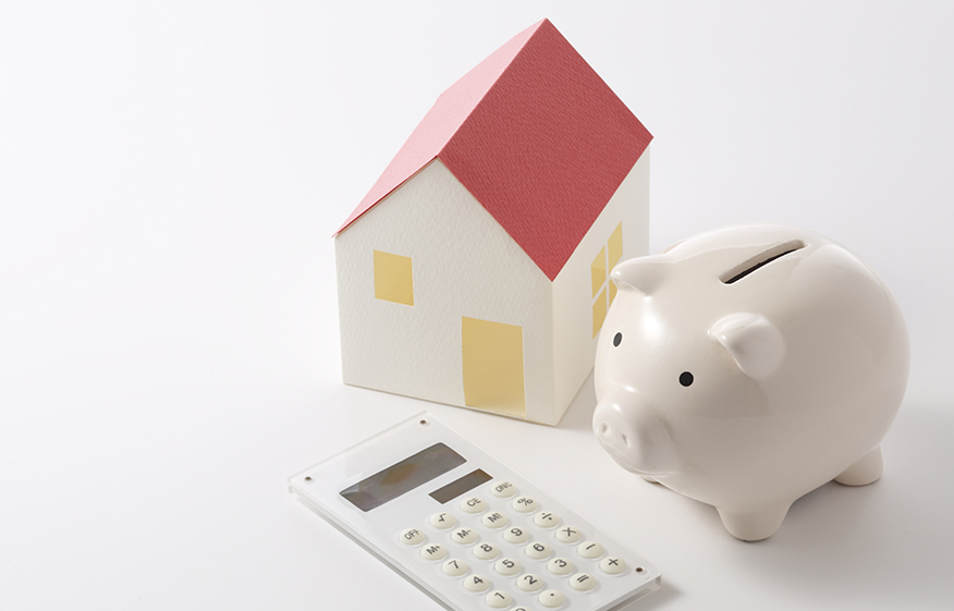 a piggy bank next to a model house and calculator