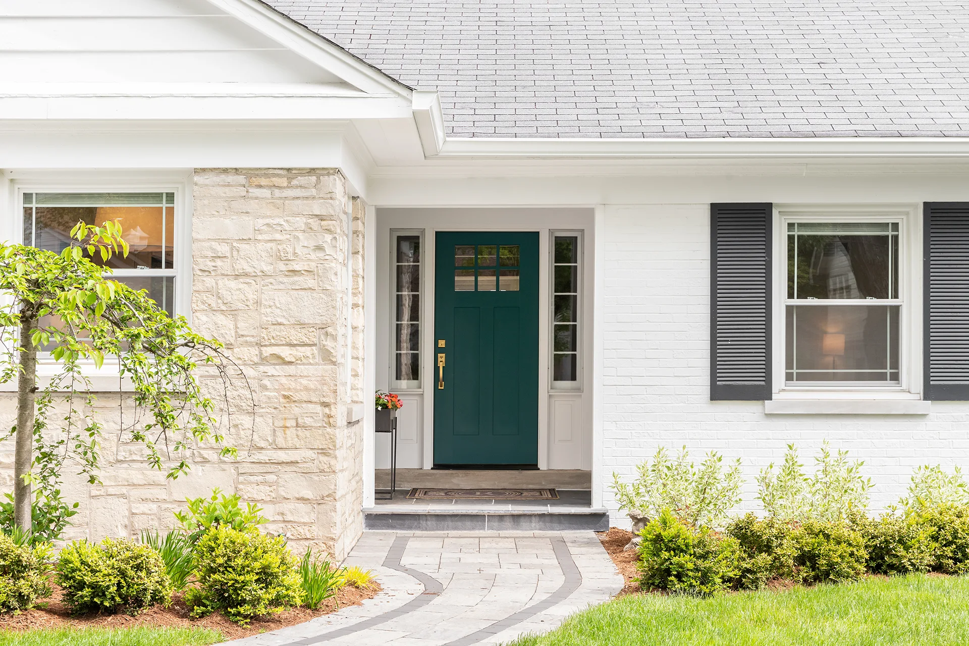 front door on home with stone and white bricking siding